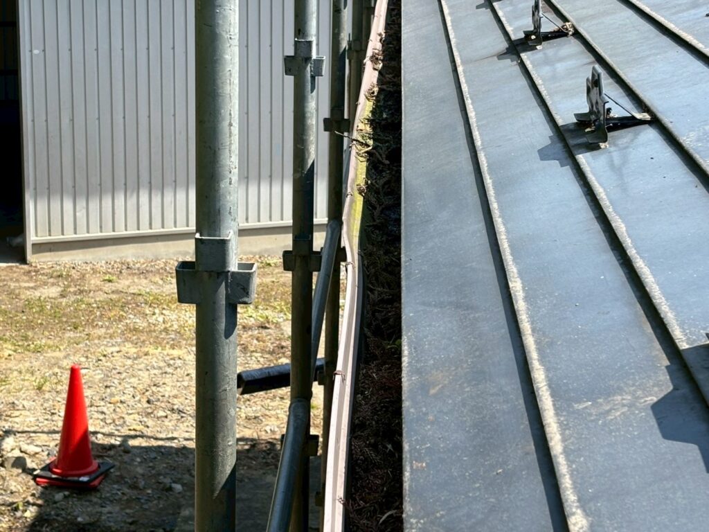 富谷市の住宅で施工前の雨樋内部に大量の落ち葉や土砂が堆積している様子